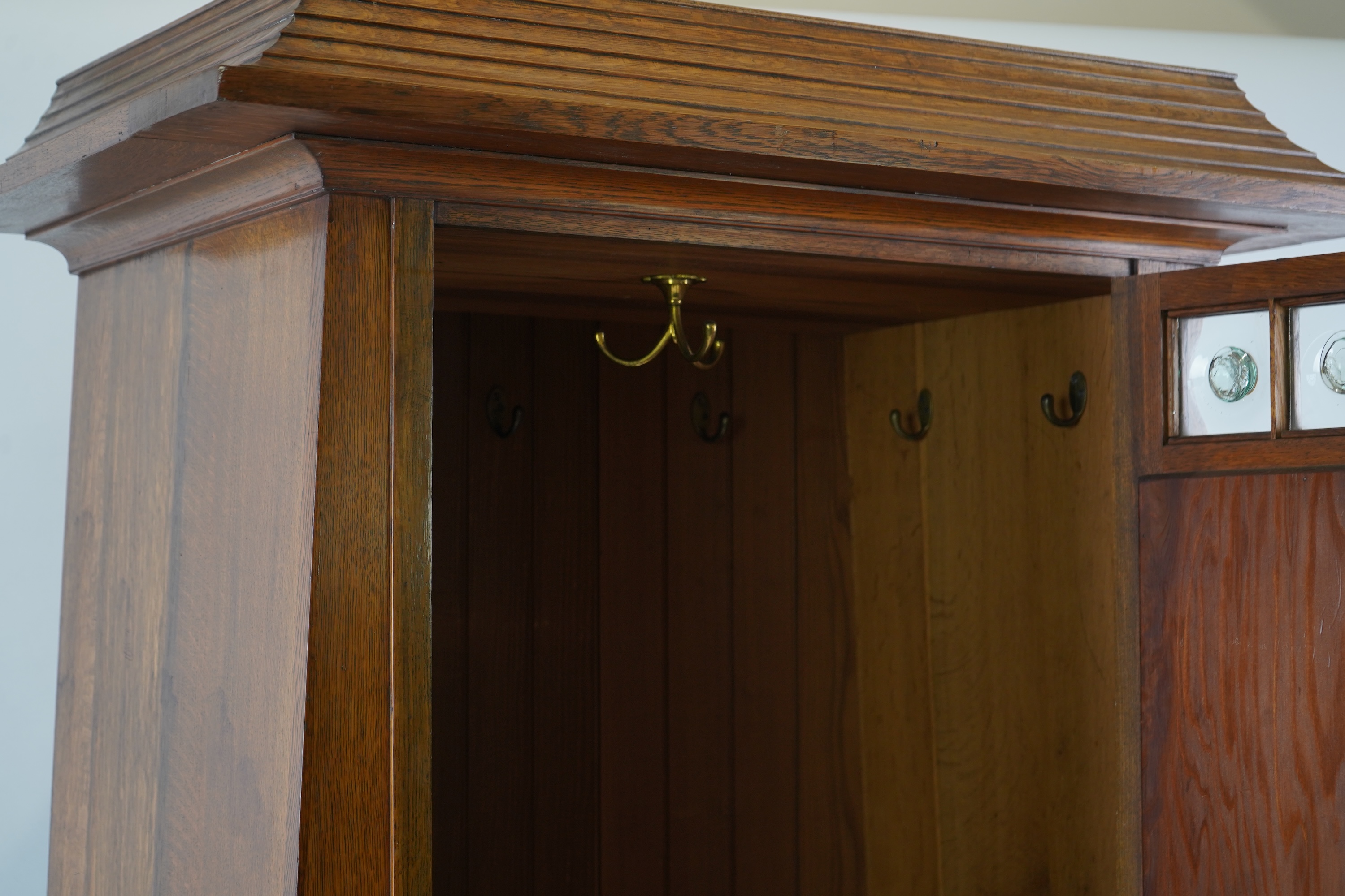 Manner of Liberty & Co: An Arts and Crafts Egyptian revival copper mounted oak wardrobe